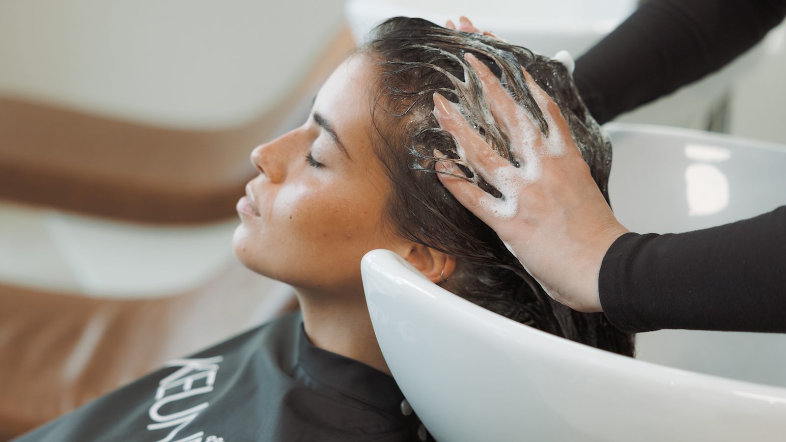 Klant krijgt bij de kapper een haarwasbeurt met Long & Strong shampoo