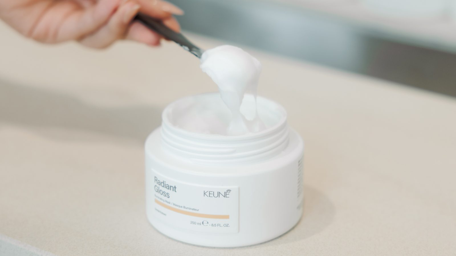 Geopende pot Radiant Gloss Illuminating Mask met een schepje erin