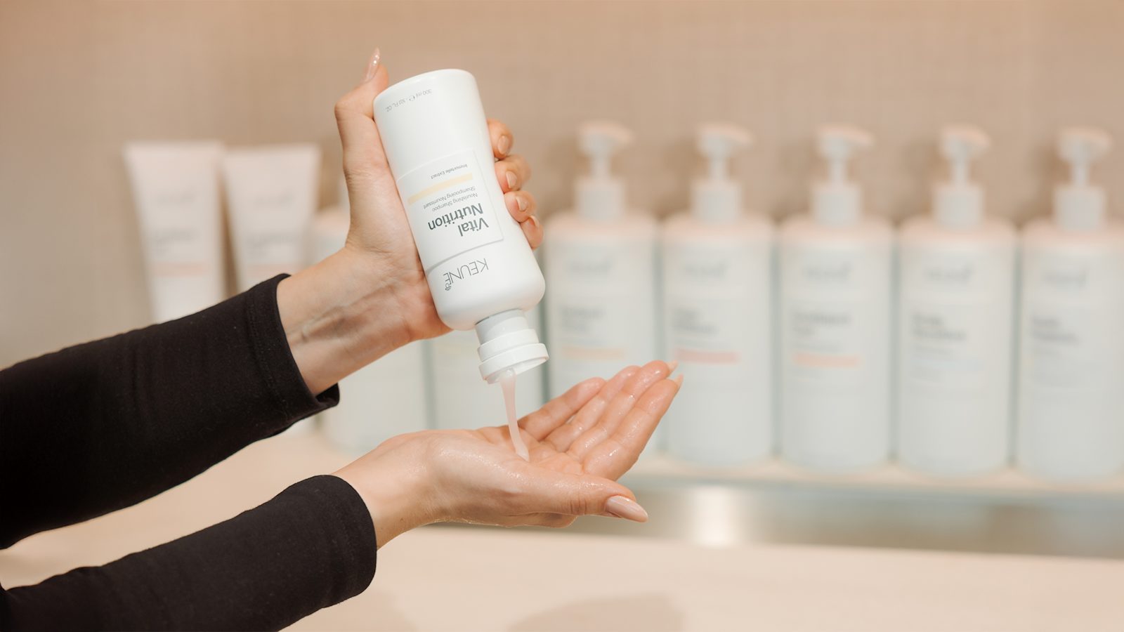 Iemand doet Keune Vital Nutrition Shampoo in de handpalm